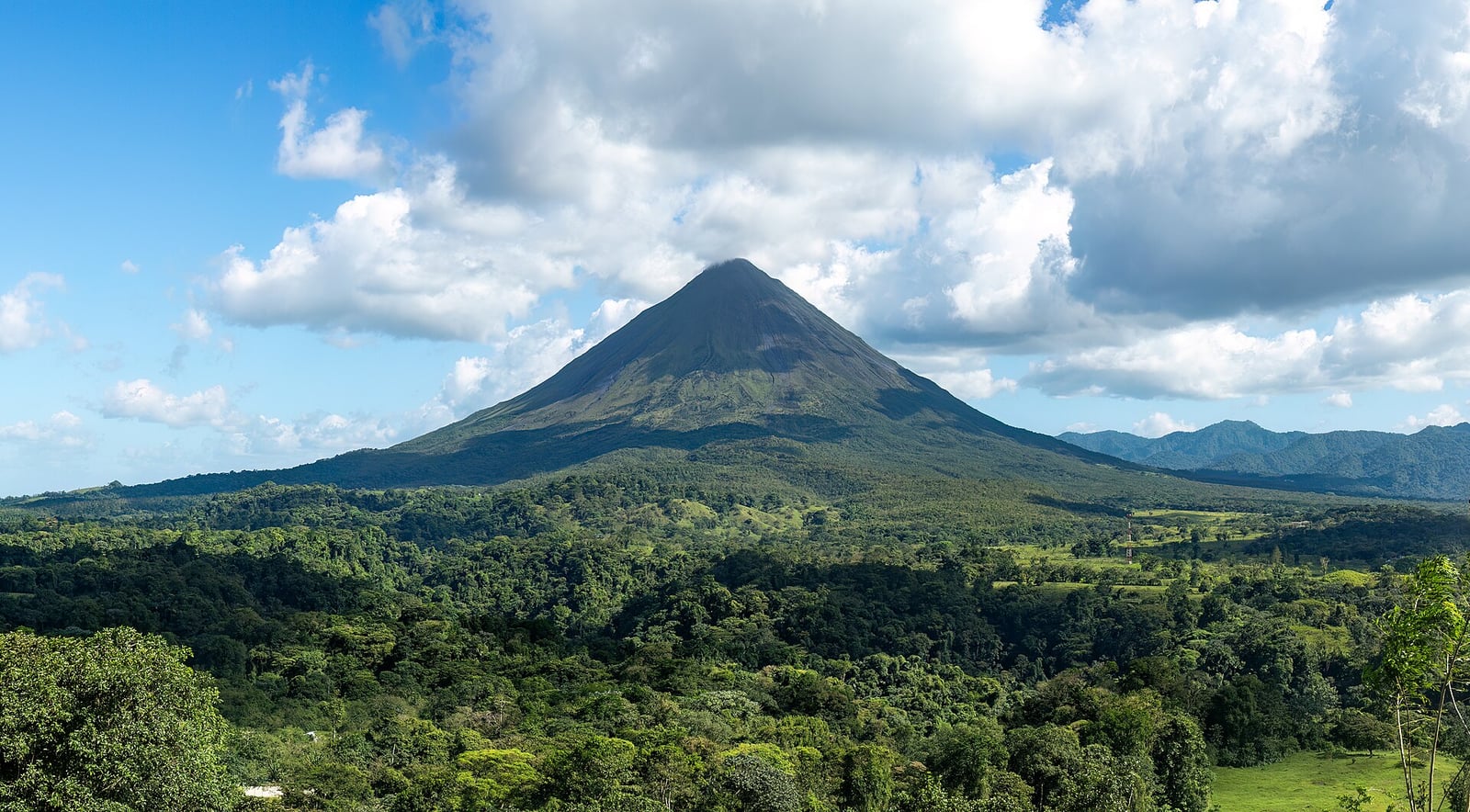 De kegel van de Arenal-vulkaan boven het regenwoud