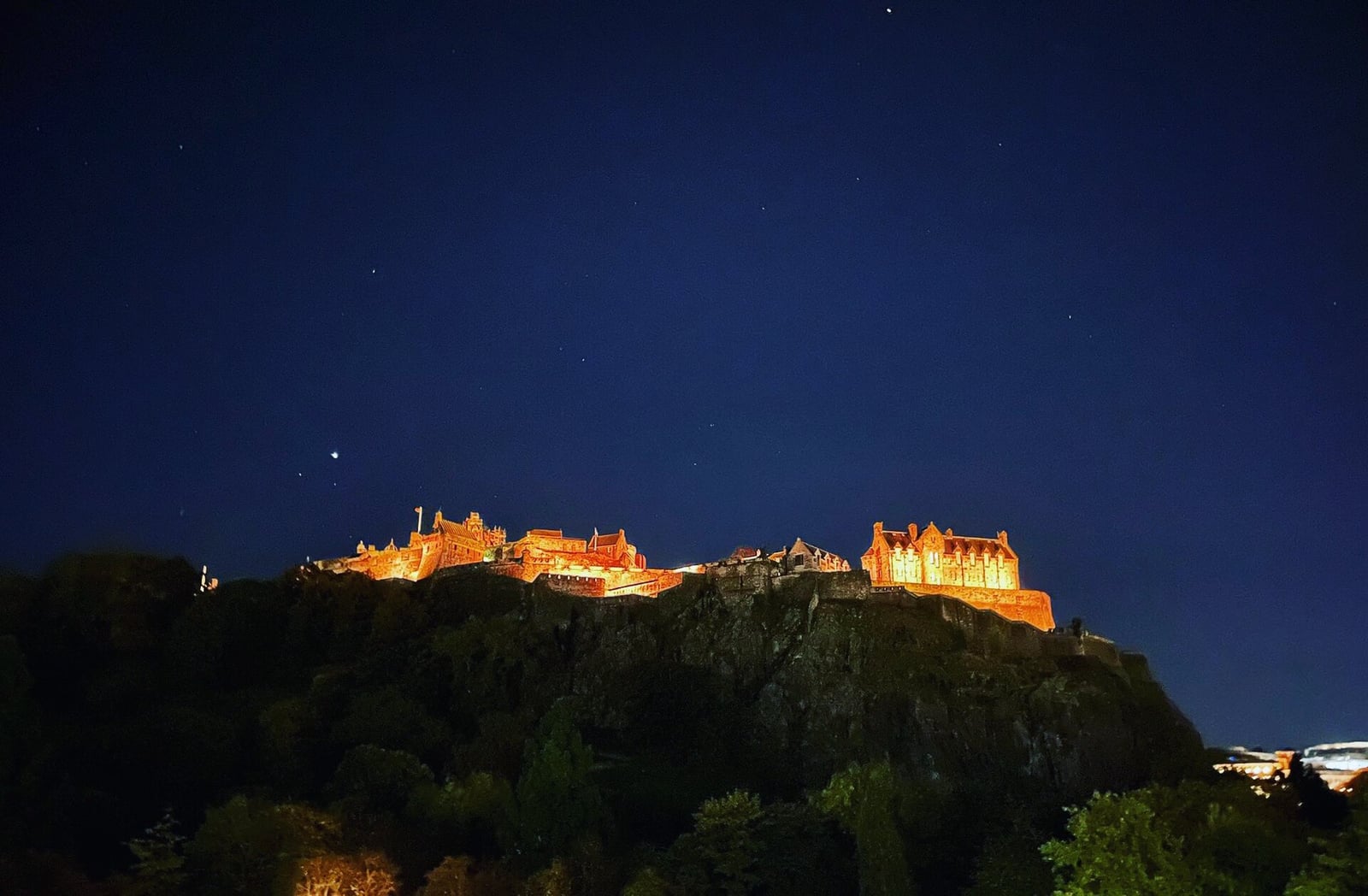 Le château d'Édimbourg éclairé en orange pour Halloween, la nuit